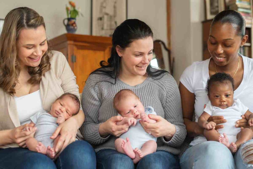 tre mamme con figli piccoli in braccio