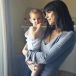 donna con in braccio un bambino piccolo