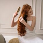 donna che si pettina i capelli lunghi e rossi