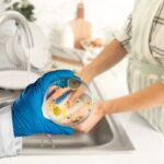 donna che lava piatti e vetrino con germi e batteri